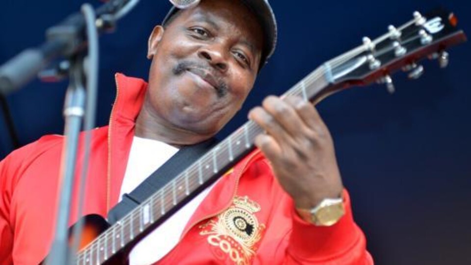 Diblo Dibala joue de la guitare sur une scène.