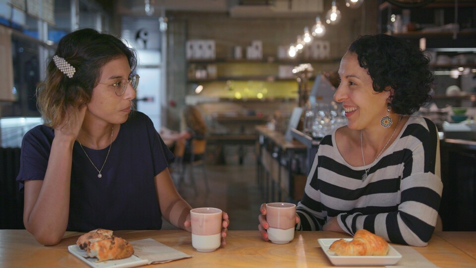 Deux femmes assises prennent un café.