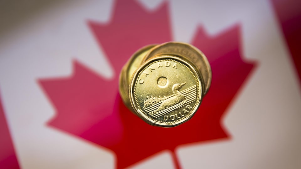 Des dollars canadiens sur un drapeau canadien.