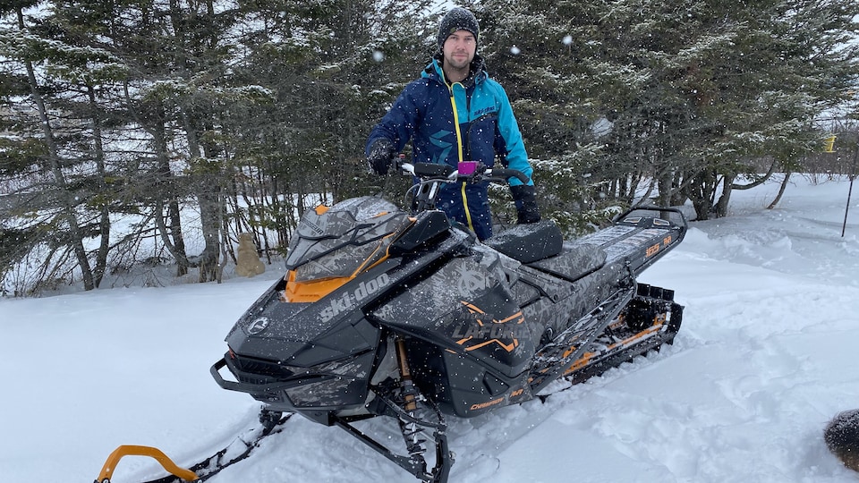 Donat Lebrasseur avec sa motoneige dans le bois