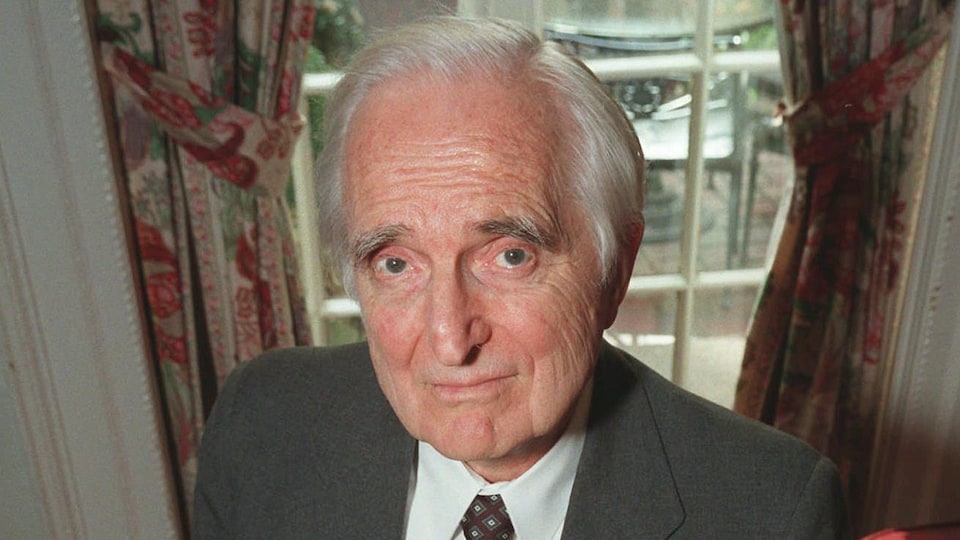 Une photo d'archives de Douglas Engelbart. Sur cette photo, il a les cheveux blancs et porte un complet gris, une chemise blanche et une cravate foncée.
