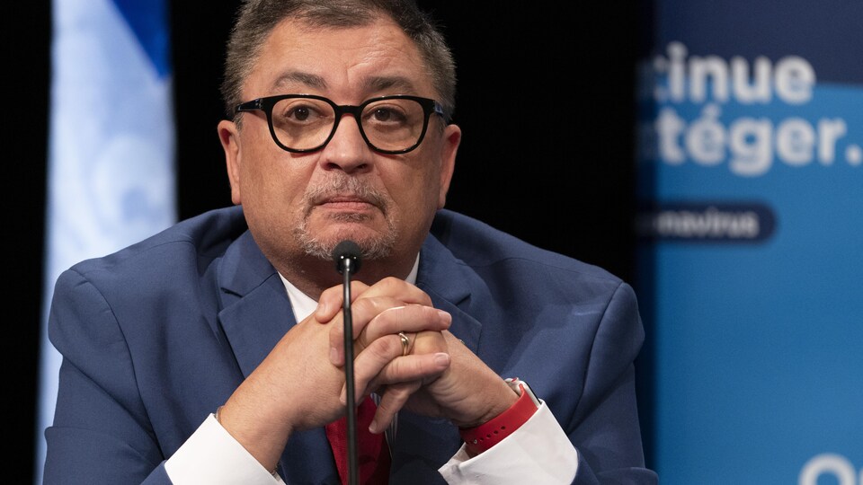 Le Dr Arruda regarde devant lui, en conférence de presse, attablé derrière un micro.