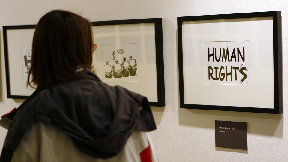 Une femme devant des dessins présentés lors d'une exposition sur les droits de l'homme, au siège de l'Organisation des Nations Unies, à New-York.