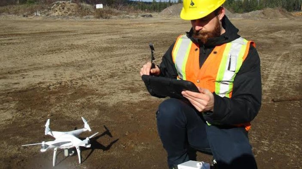 Un travailleur forestier utilisant un drone.