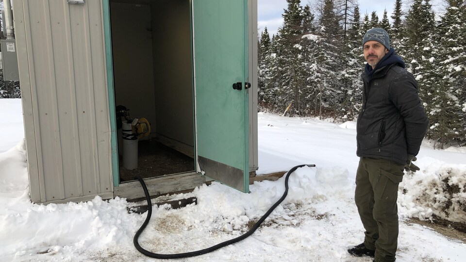 Jean-Philippe Tremblay, hydrogéologue associé chez Laforest Nova Aqua, dehors, près d'une petite cabane avec un système pour pomper l'eau.