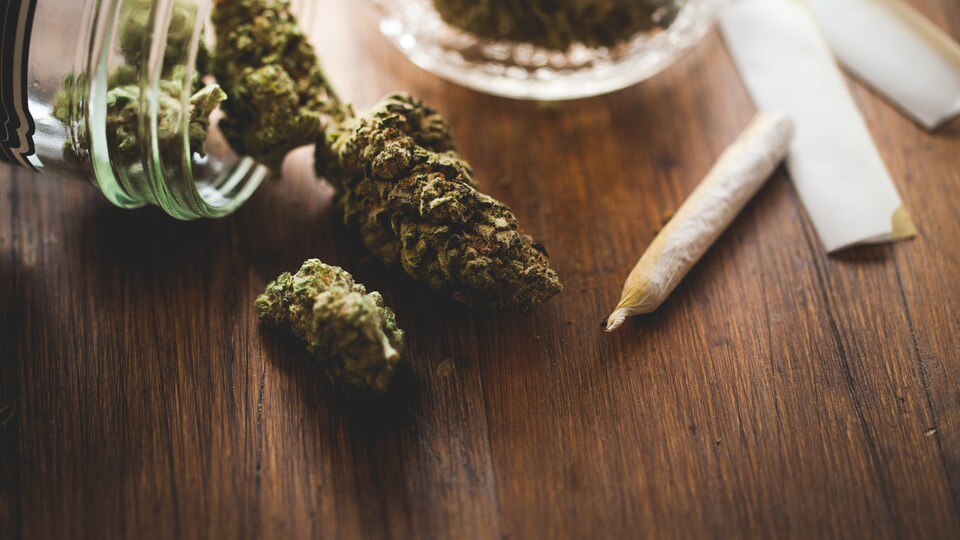 Du cannabis et un joint disposés sur une table.