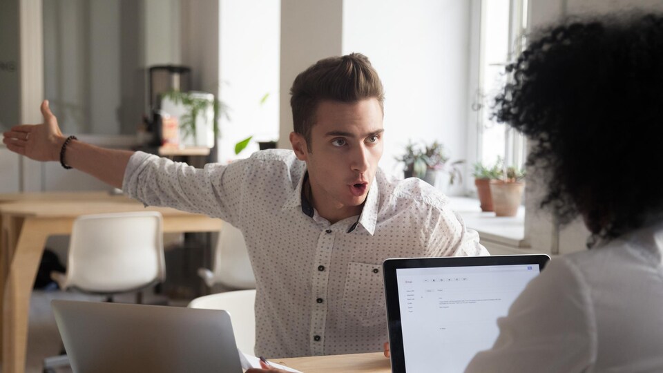 Un homme semonce sa collègue de travail.