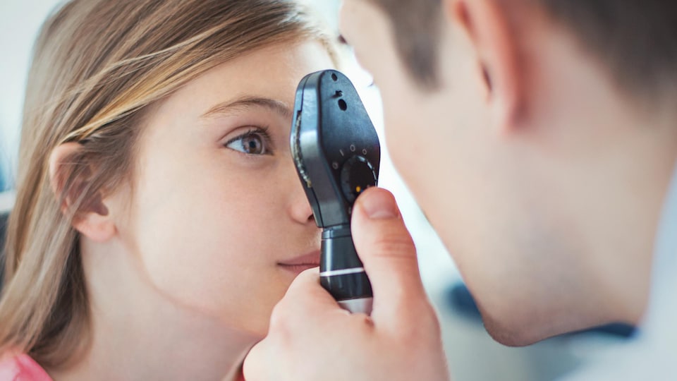 Un optométriste examine une fillette.