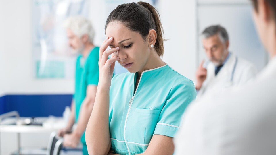 Une infirmière semble épuisée par son travail.