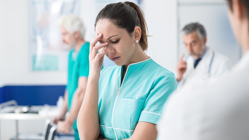 Une infirmière semble épuisée par son travail.