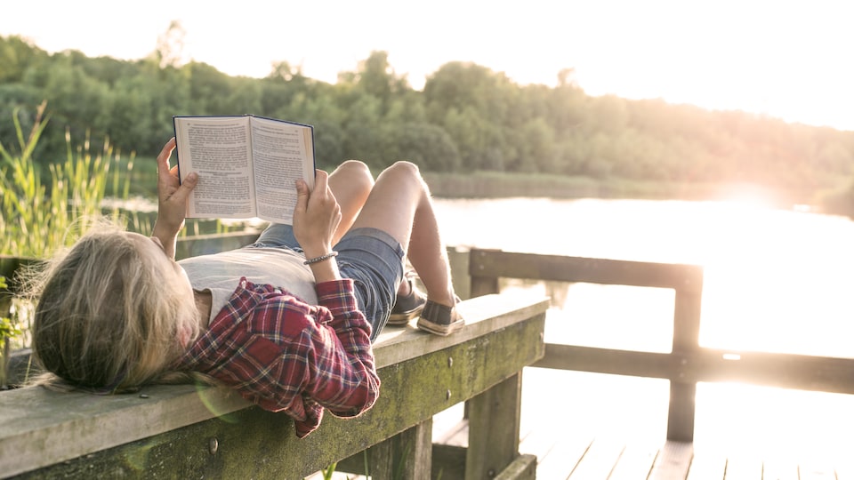 Une jeune fille lit un livre.