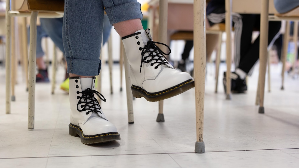 Les bottes d'une élève sous son bureau. 