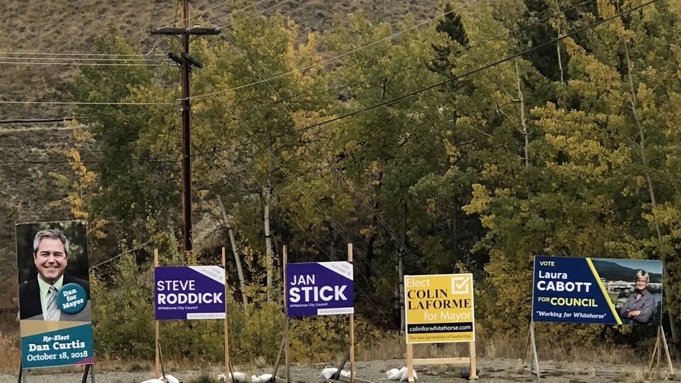 Des panneaux électoraux sont plantés au bord de la route.
