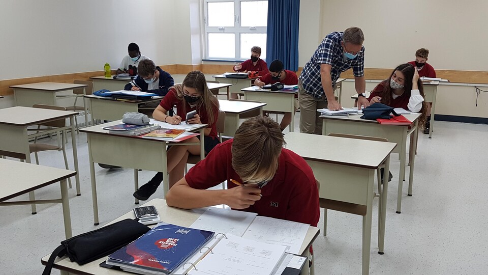 Des élèves dans une classe du secondaire avec leur enseignant.