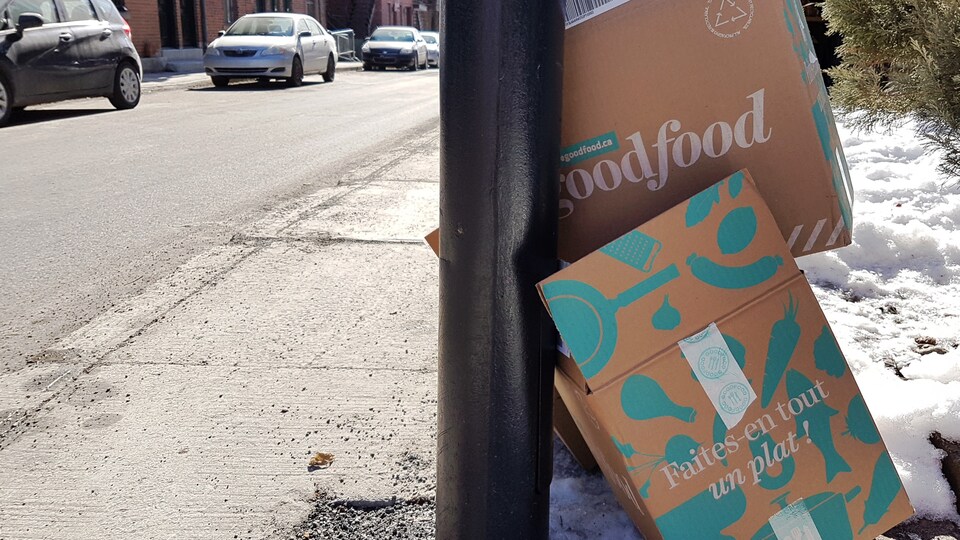 En bordure d'une rue, des boîtes de carton de l'entreprise Goodfood, qui livre des repas prêts à cuisiner.