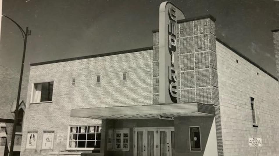 Une photo en noir et blanc d'un édifice avec le texte «Empire theatre, Cochrane, Ont.».