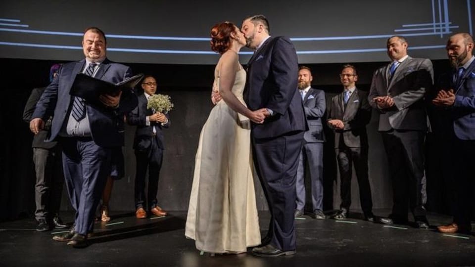 Éric Veillette embrasse son épouse lors de son mariage célébré dans le cinéma Revue.