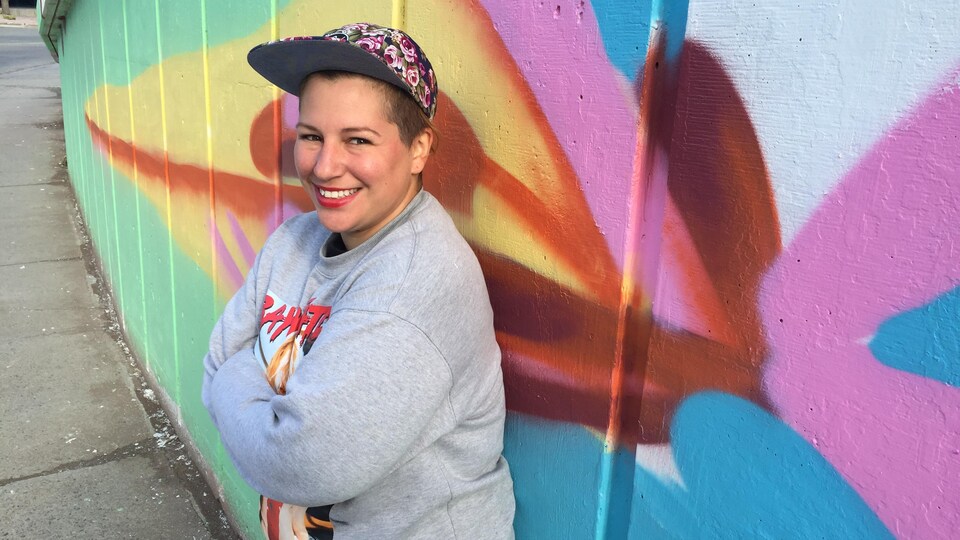 Mique Michelle devant un mur de béton coloré