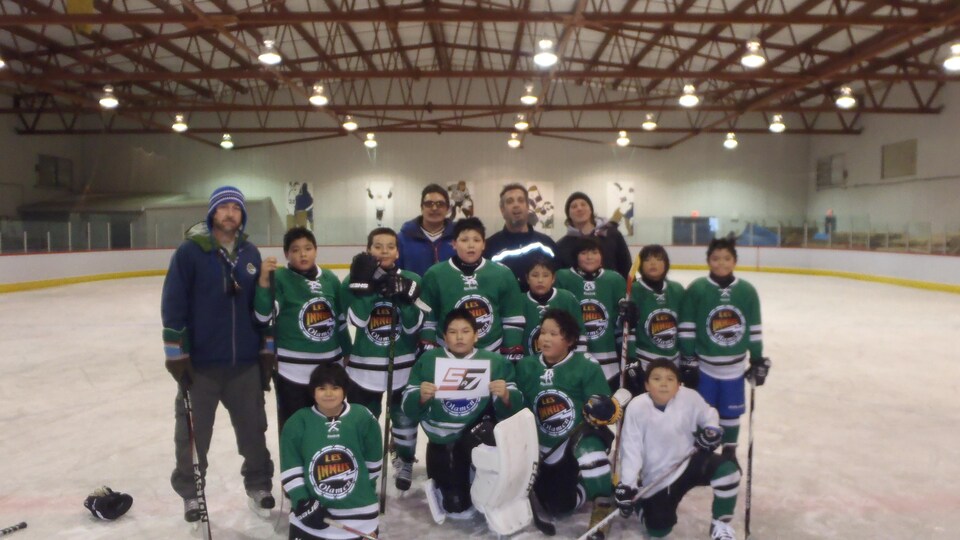 L'équipe de jeunes joueurs de hockey de Unamen Shipu, avec l'entraîneur Ben Côté.