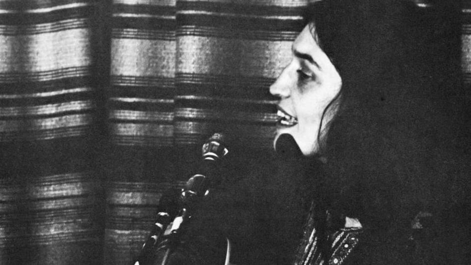 Elle chante guitare à la main.