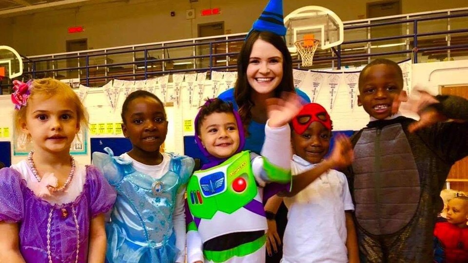 Jacqueline est dans un gymnase d'école avec cinq élèves de la maternelle, tous sont habillés en costumes d'Halloween