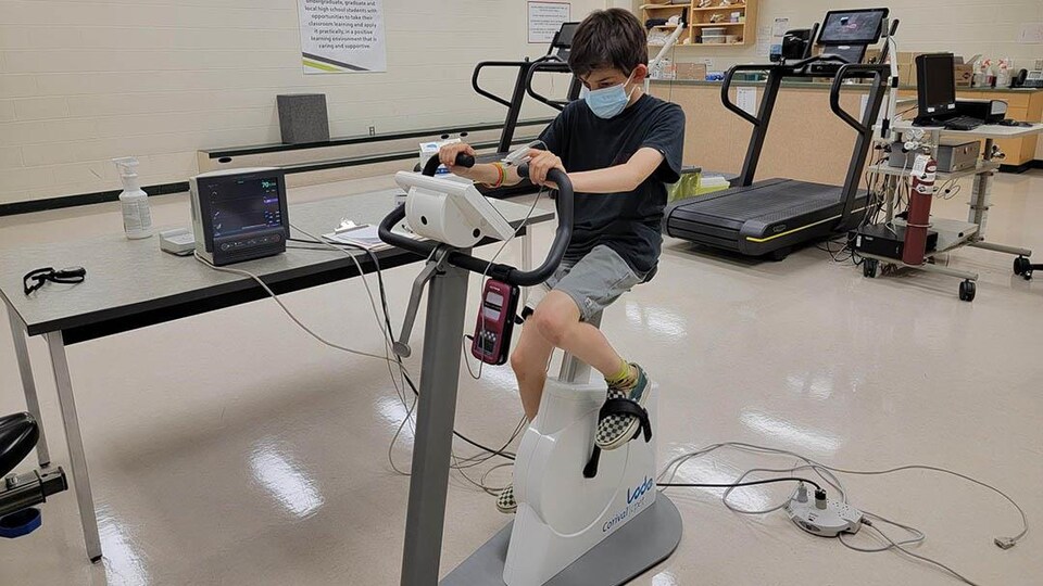 Un jeune se trouve sur un équipement de sport dans un laboratoire de l'Université de la Saskatchewan.