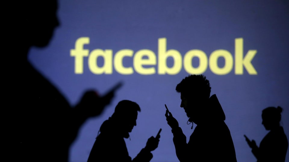Des personnes regardent leur téléphone avec le logo de Facebook en arrière-plan.