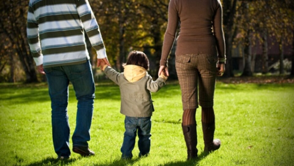 Un père, une mère et leur fils main dans la main