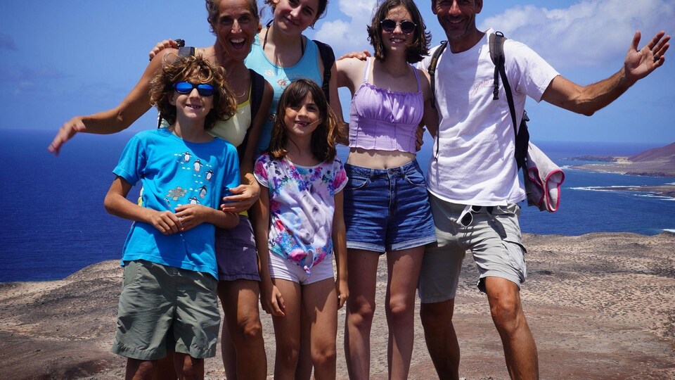 Des parents et des enfants devant la mer. 