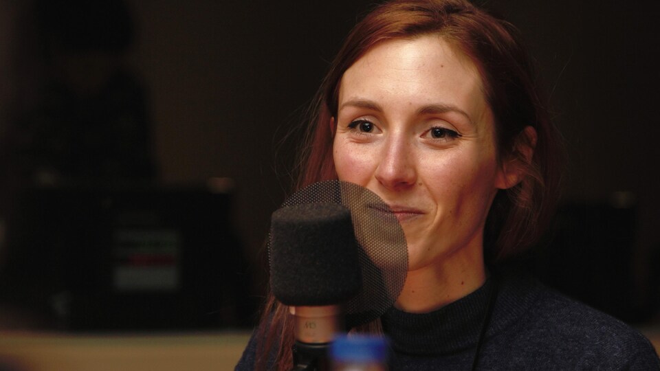 Fanie Demeule souriant dans un studio de radio.
