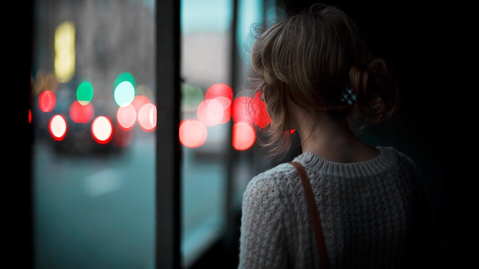 Femme vue de dos, dans une ambiance sombre et étouffante.