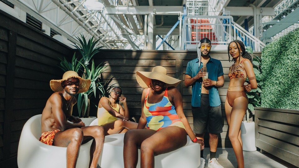 5 personnes, dont 3 sont assises et 2 debout. Tous les 5 en maillot de bain dans un centre aquatique. 