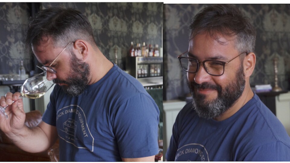 Le sommelier Florian Monchy-Olivet qui boit du vin et qui sourit sur le deuxième plan.
