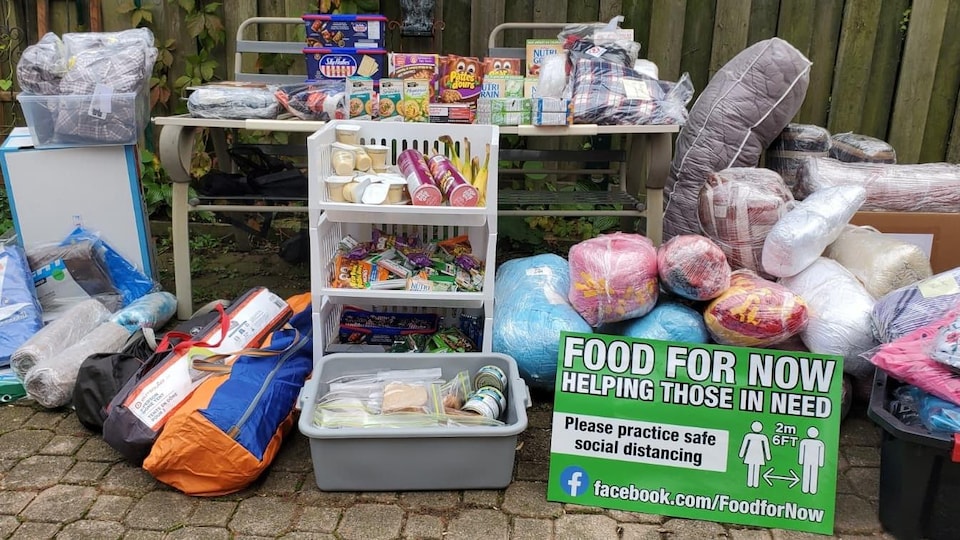 Des denrées non périssables et une affiche avec l'inscription «Food for Now».