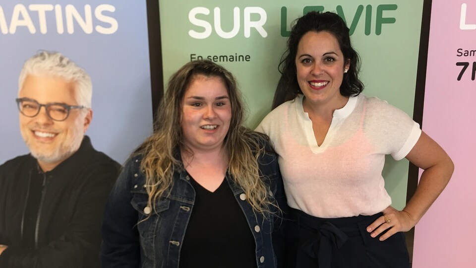 Les deux femmes posent pour la caméra en souriant.
