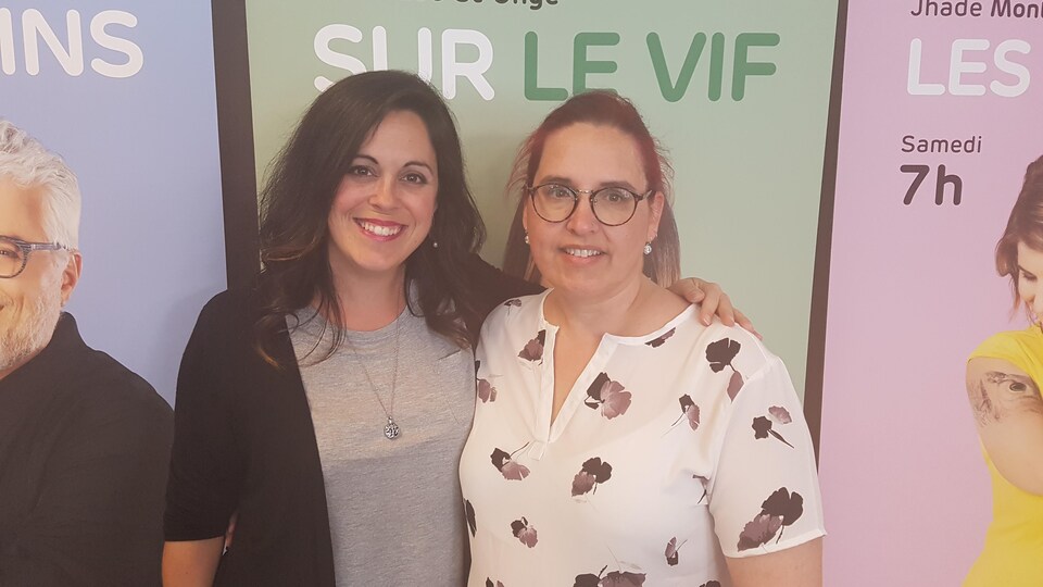 Les deux femmes posent pour la caméra en souriant.