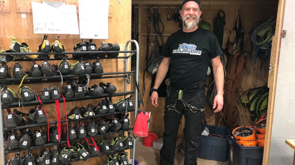 Fred Fournier, co-propriétaire de l'entreprise Attitude nordique, dans un local avec des souliers d'escalade