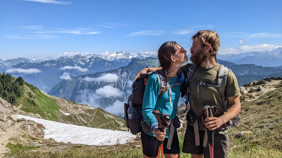 Photographie de Gabriel Champigny et d'Élise De Barba s'embrassant devant des montagnes.