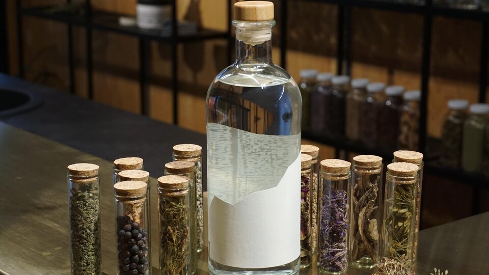 Une bouteille vide entourée de petites fioles remplies d'aromates.
