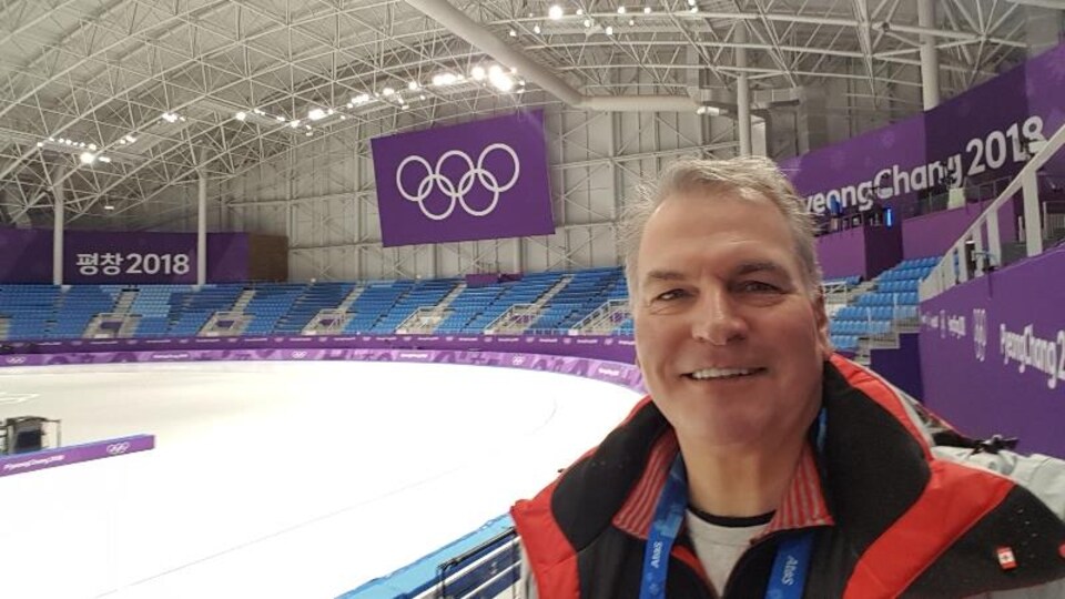 Portrait de Robert Boileau dans les gradins d'une aréna de PyeongChang.