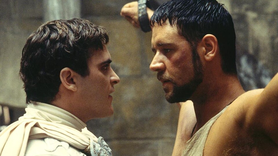 Un empereur romain parle à quelques centimètres du visage d'un gladiateur enchaîné.