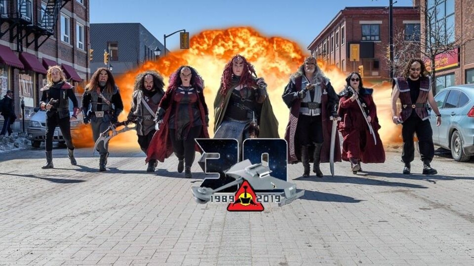 Huit personnes déguisées en Klingon marchent dans les rues du centre-ville de Timmins, devant une explosion.