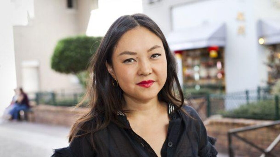 Elle sourit à la caméra.