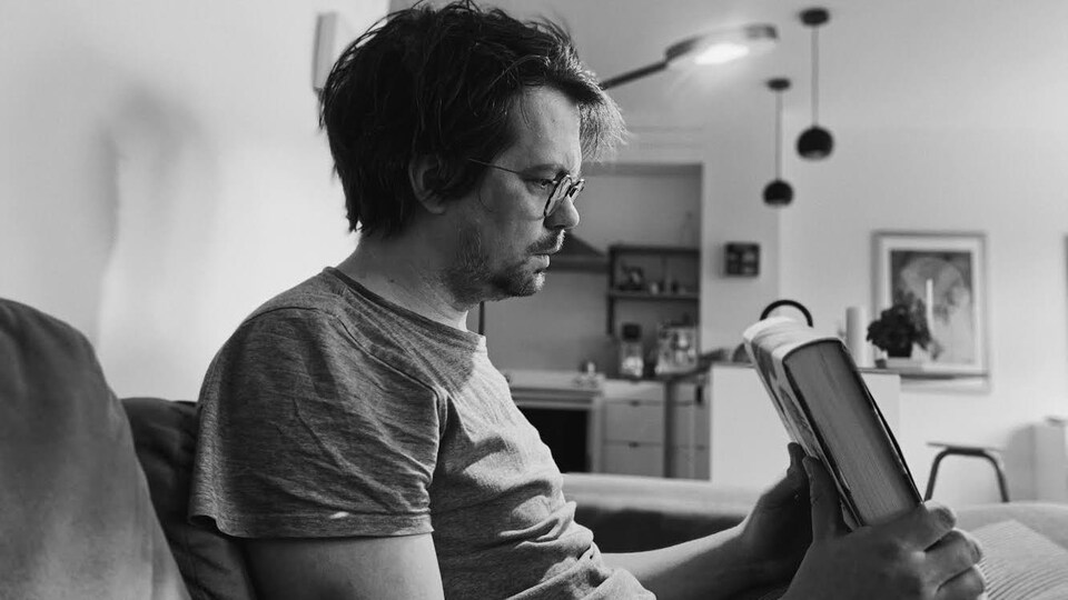 Il regarde un livre.