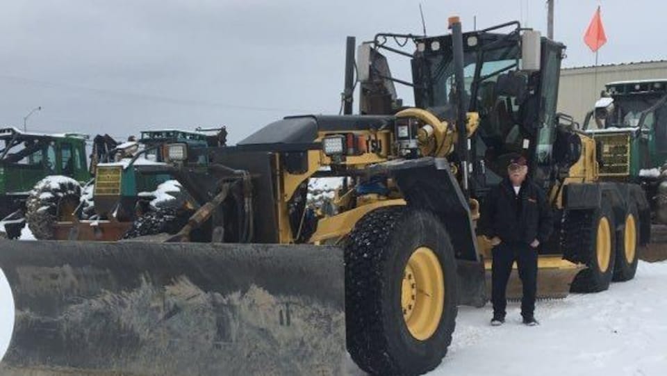 Un homme devant de la machinerie lourde.