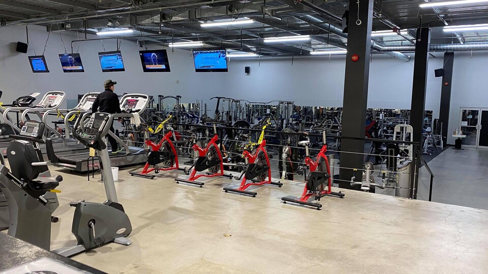 La salle d'entraînement du Complexe Maxi Forme à Baie-Comeau : une personne s'entraîne sur un tapis roulant.