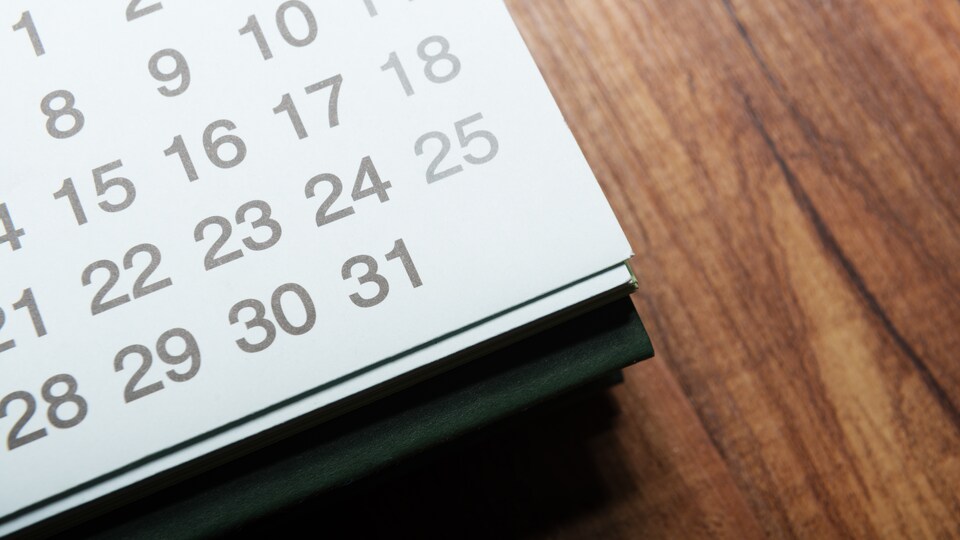 Un calendrier posé sur une table en bois.