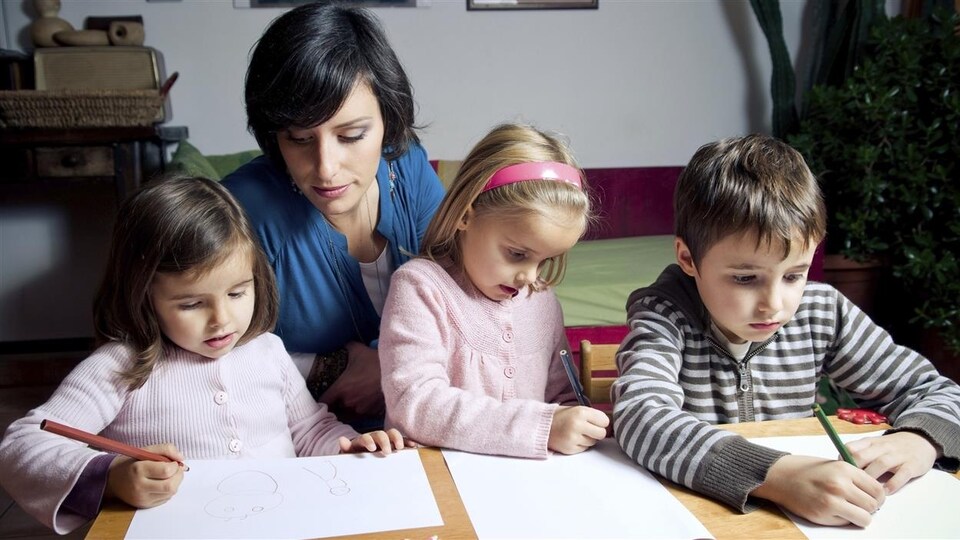 Une mère fait l'école à la maison à ses enfants.