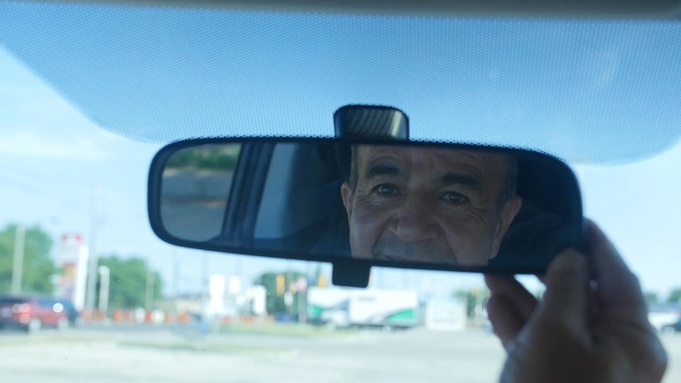 Le reflet d'un homme dans un miroir d'auto.