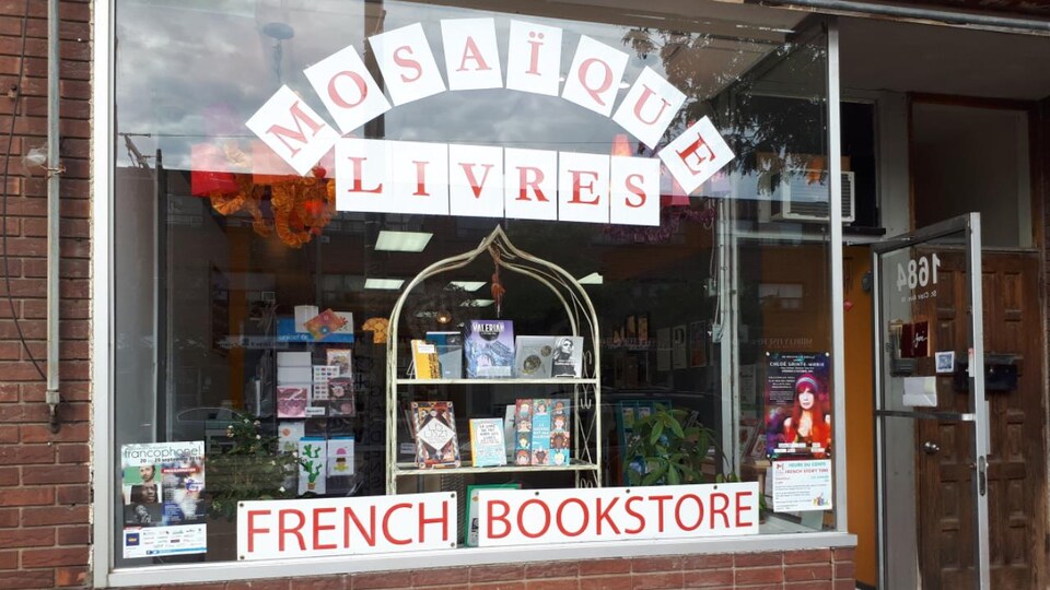 Fenêtre de la librairie Mosaïque de Toronto avec un étalage de livres.